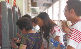 The volunteers demonstrated how to use the ATM to the elderly as the elderly told them the difficulties they encountered when using the machine.